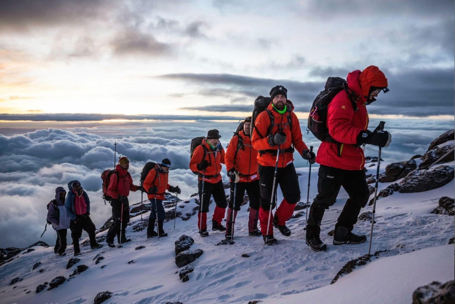 A line of climbers in winter clothing on the snow near Kilimanjaro's summit